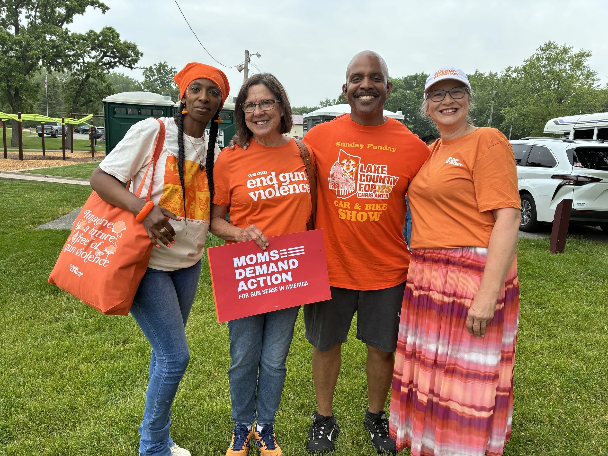MOMS DEMAND ACTION FOR GUN SENSE IN AMERICA smiling with Edward Jenkins for Lake County, Indiana Sheriff, the current deputy chief of police for Lake County, at an event.