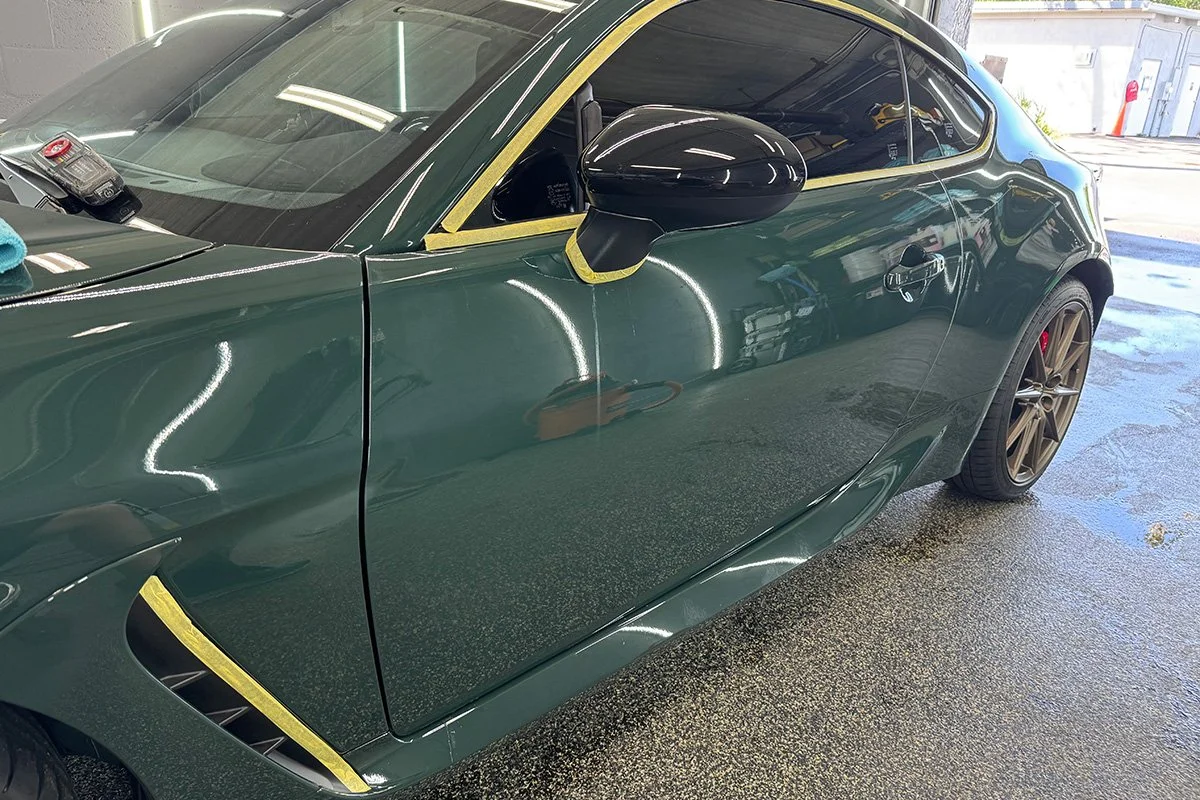 Edges masked with tape to protect trim during paint correction