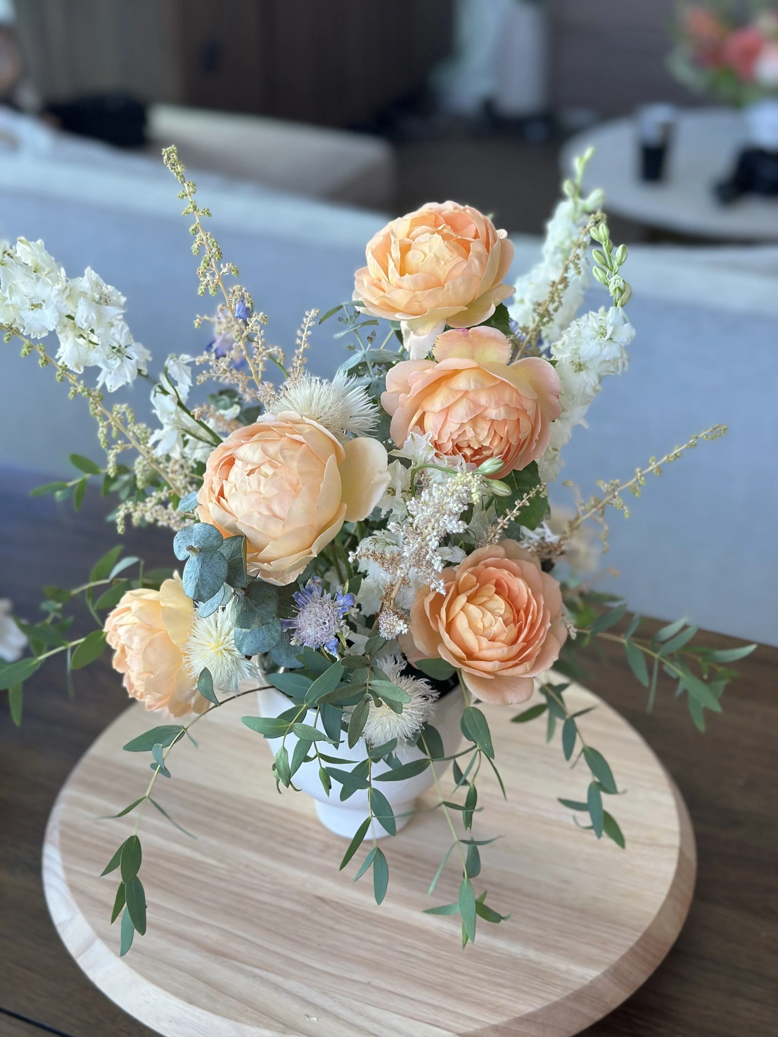 Floral arrangement with peach garden roses and eucalyptus — ceramic vase centerpiece Seattle