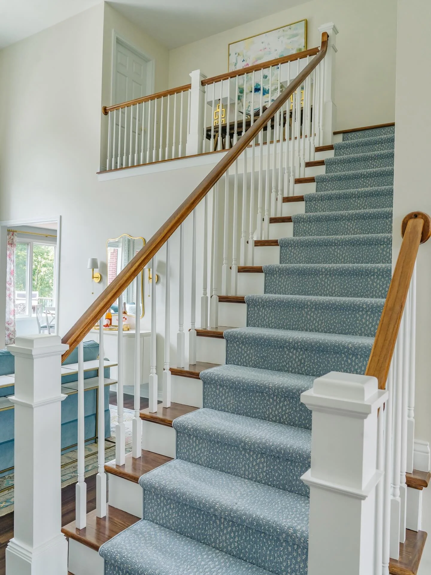 Welcome home to a little everyday magic! ✨
This cheerful foyer and staircase were designed to feel like a breath of fresh air the moment you walk through the door. We refreshed the stair treads and handrails with a deeper, richer stain and added a cu