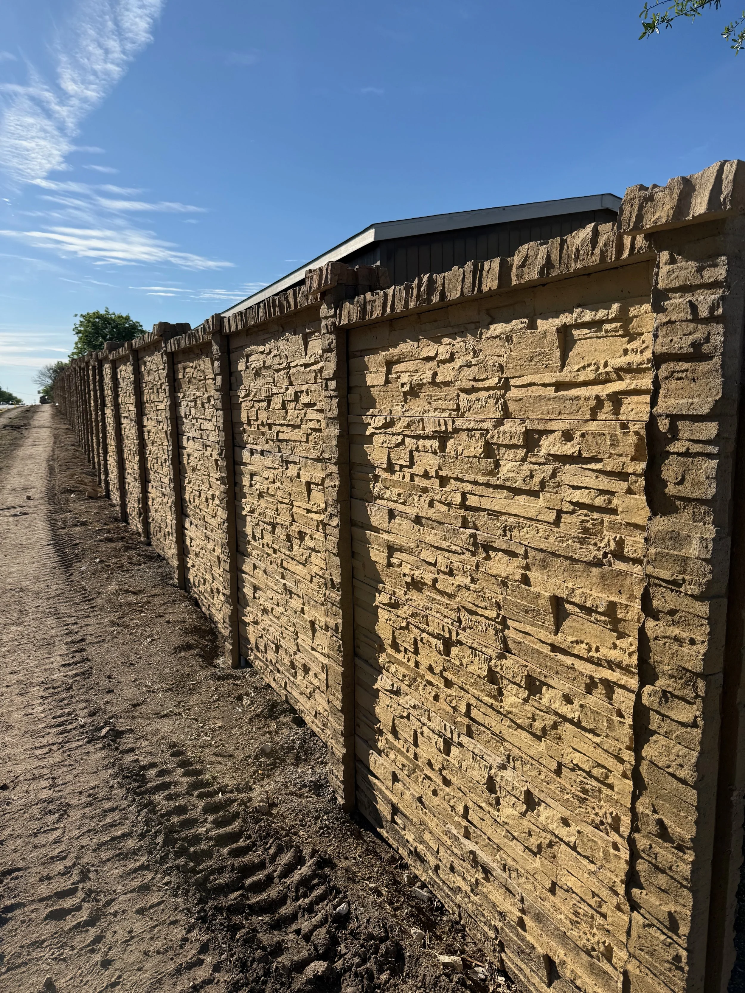 Bedrock precast concrete fence installed along road Texas
