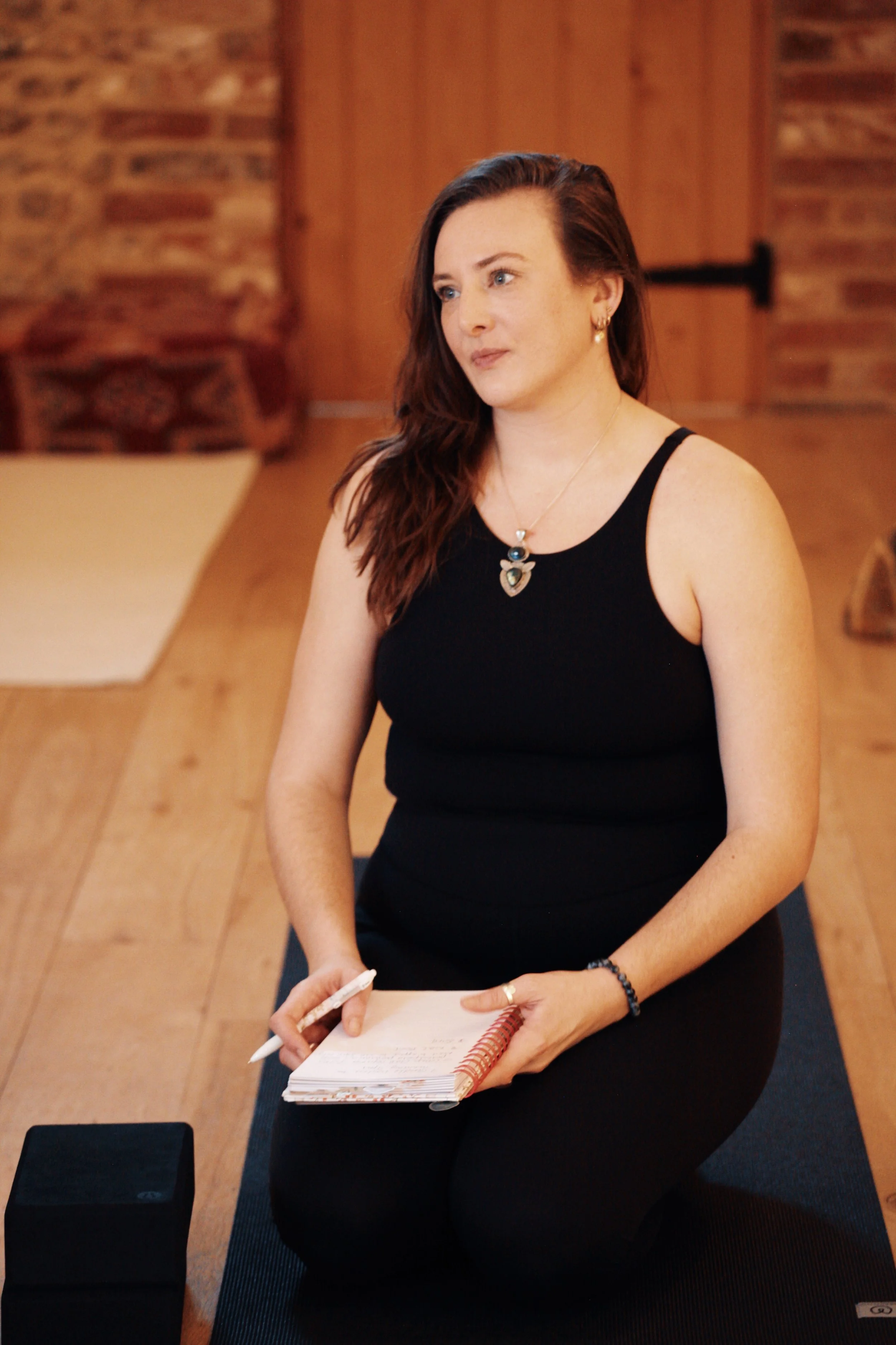 Teacher training student taking notes and reflecting on key concepts during a SoulSpace Academy training workshop.