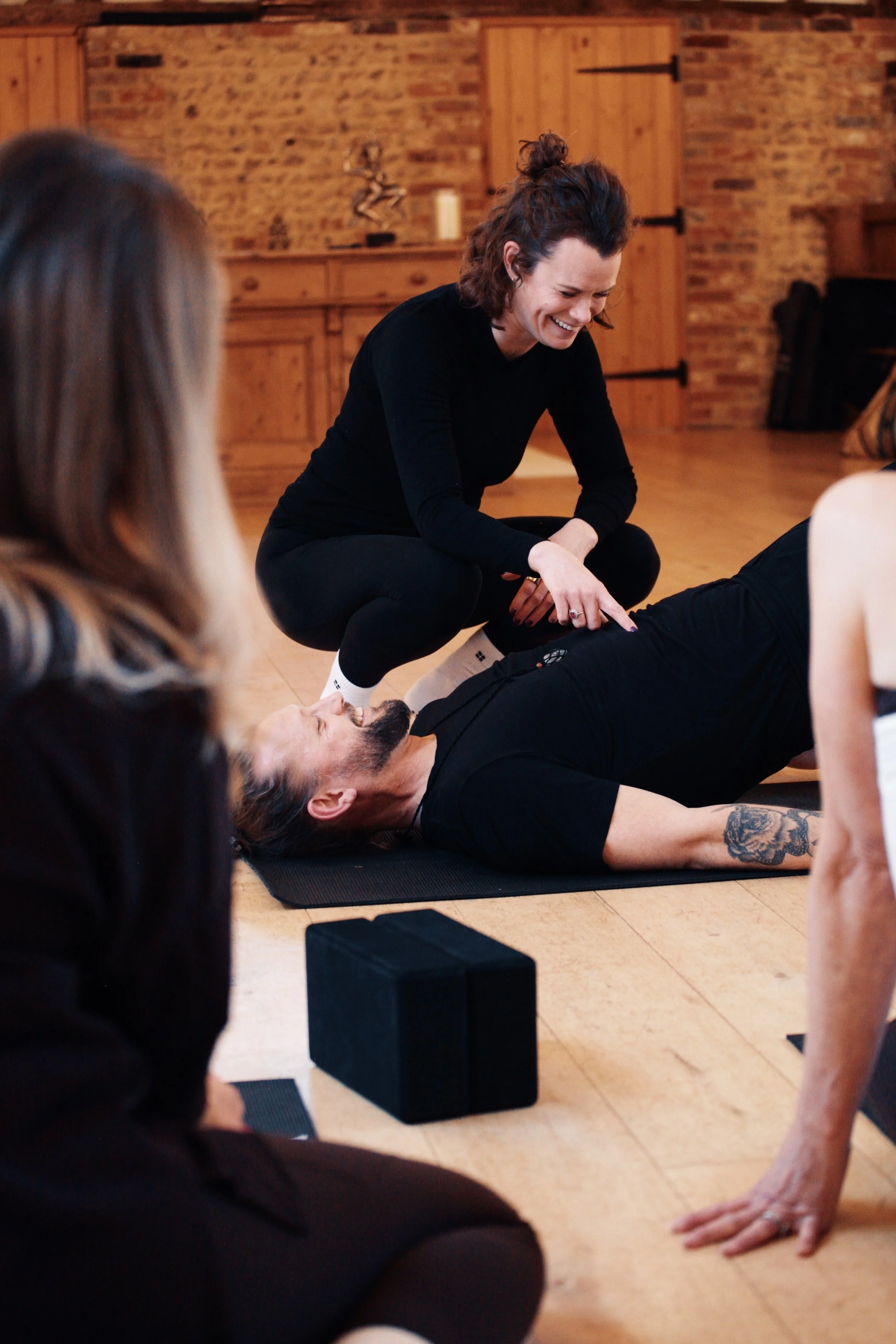 Pilates teacher trainer demonstrating hands-on movement assessment and coaching techniques during teacher training at SoulSpace Academy.