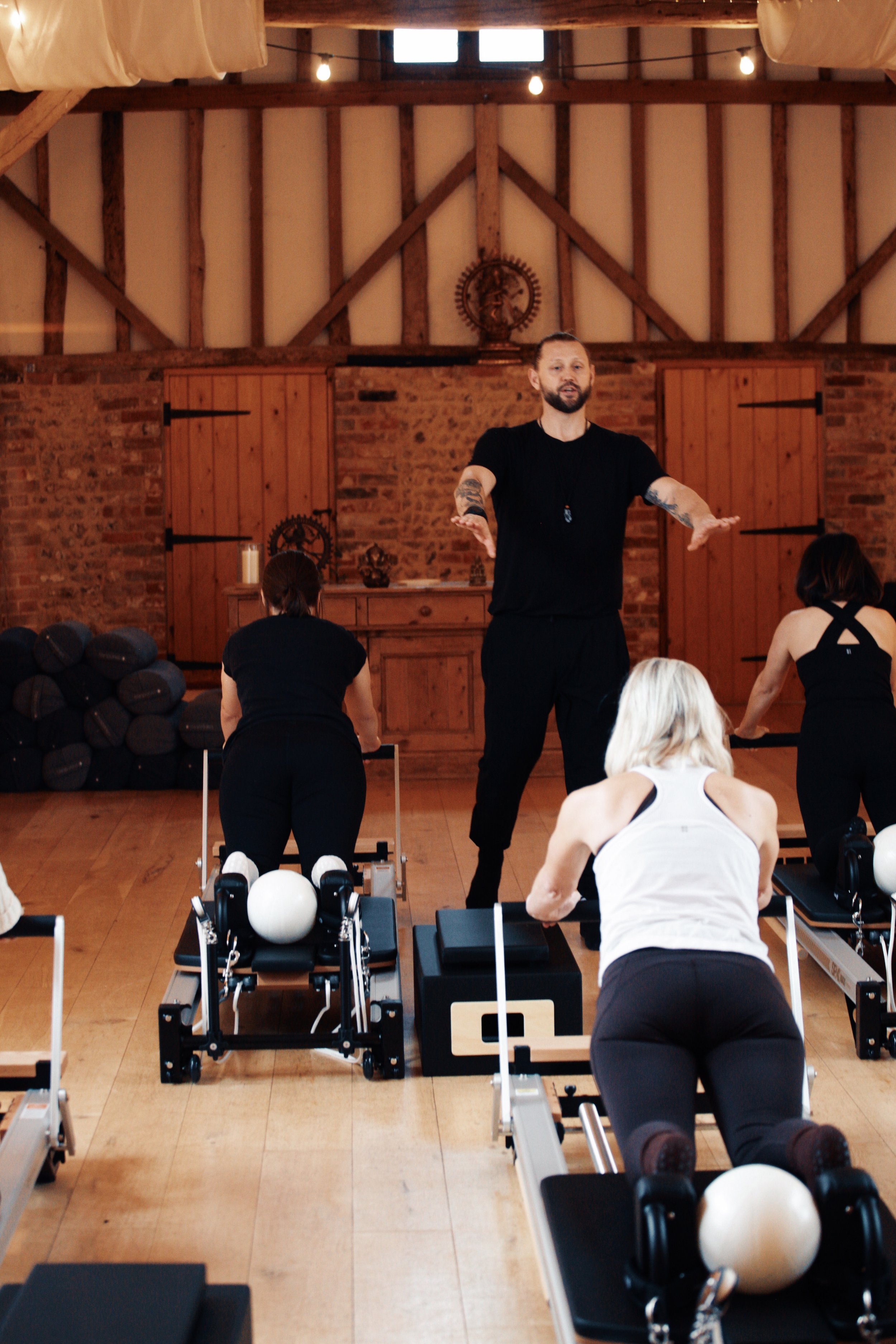 Reformer Pilates educator leading a practical instructor training session focused on technique and movement quality.