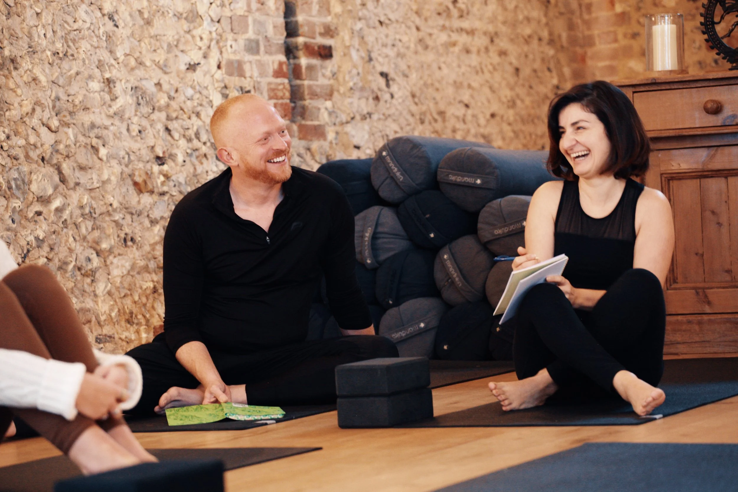 Yoga teacher training students sharing ideas and reflecting on their learning in a supportive SoulSpace Academy environment.