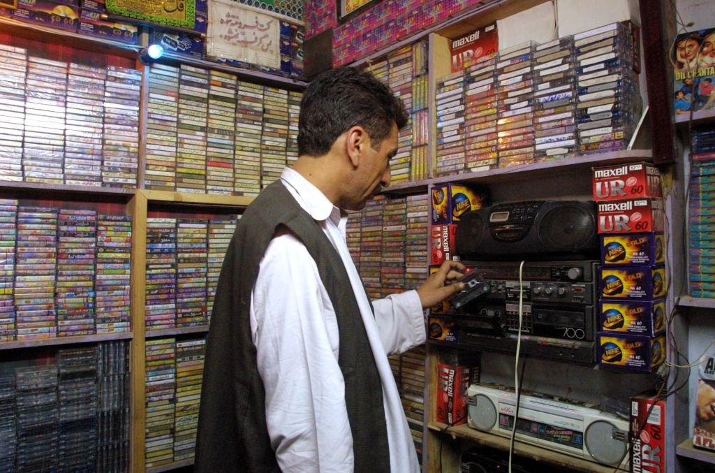 An Afghan man changes cassettes in a music shop in Herat, 2001. Music was strictly forbidden under the Taliban regime. (AFP PHOTO/Behrouz MEHRI via Getty Images)