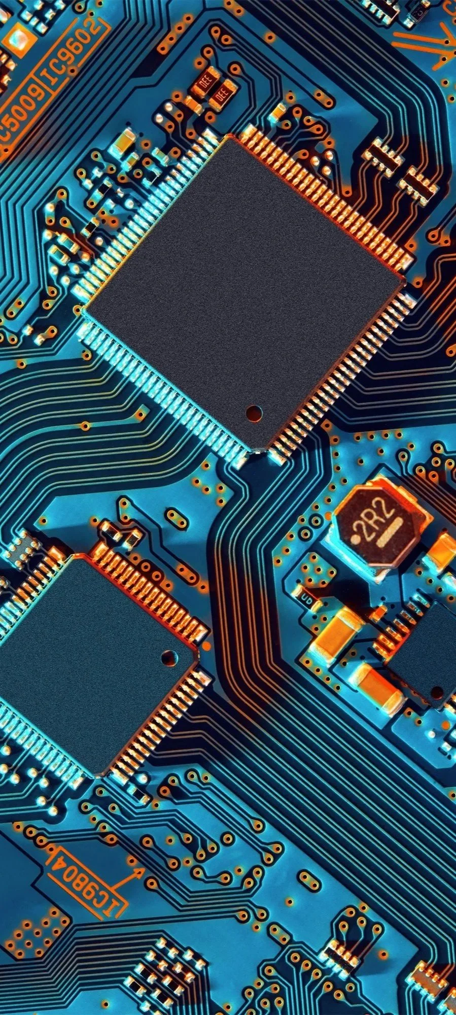 Close-up of a blue computer circuit board with integrated circuits, chips, and electronic components.