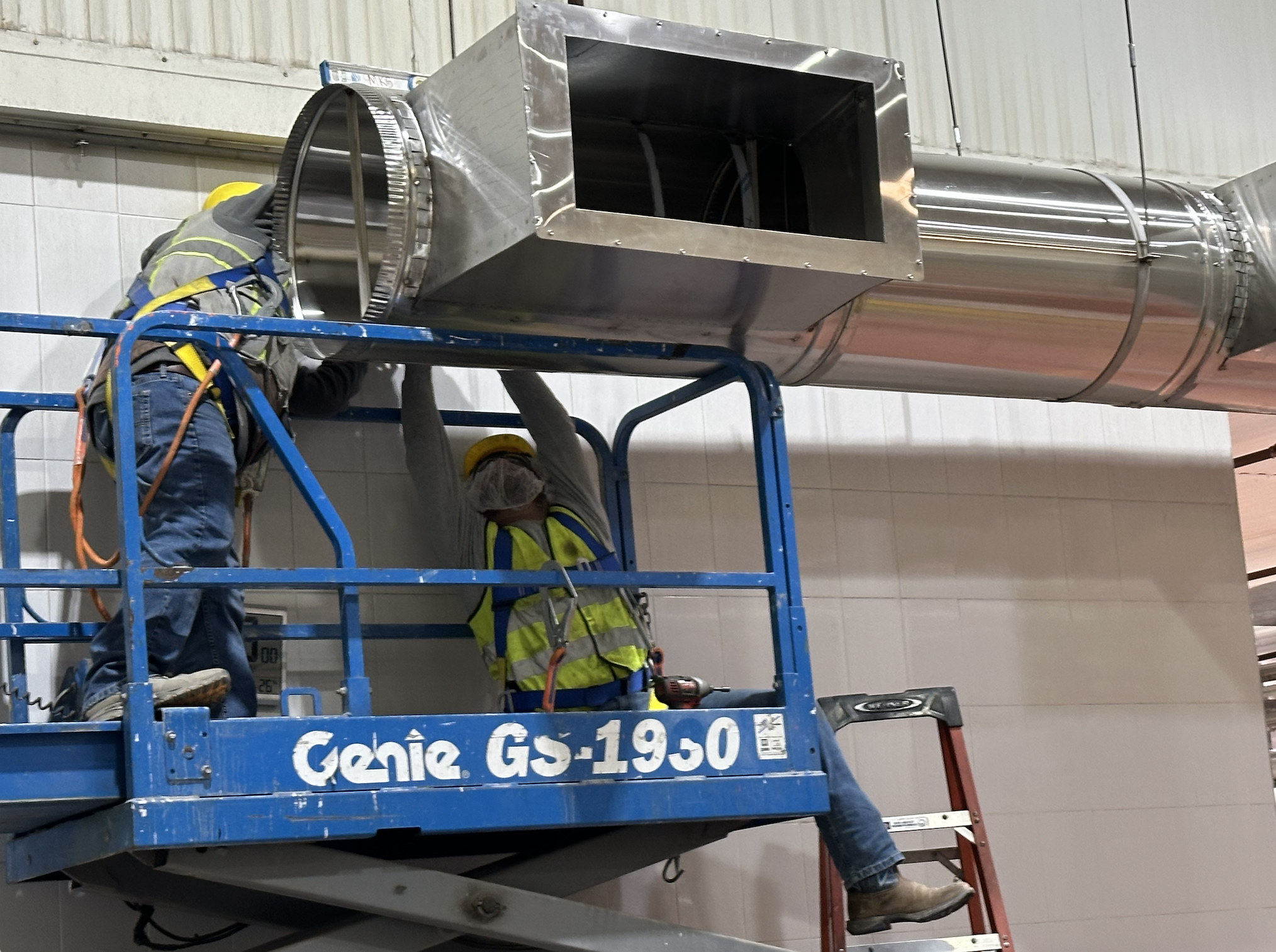 Oranssi technician working on a roof project