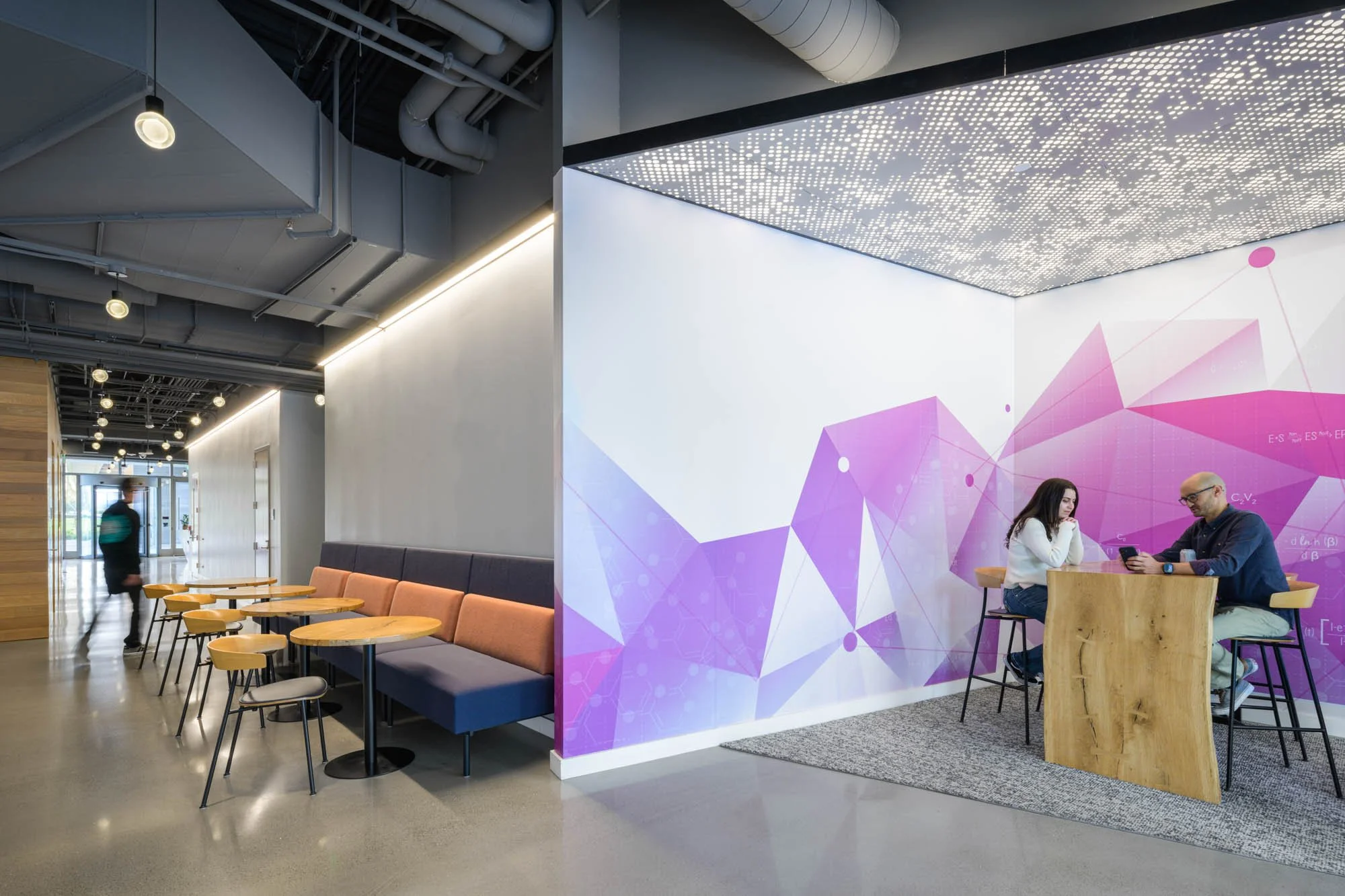 office lobby in south san francisco, with three people, geometric mural, and perforated ceiling