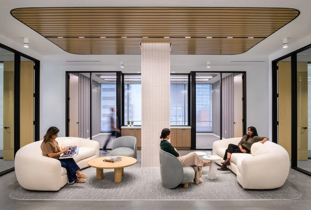 lobby of a modern office with warm wood tones, four people