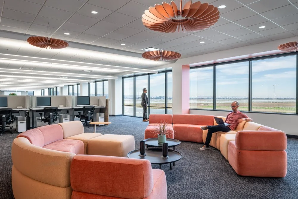 office lounge with pink circular couches, and pink light fixtures