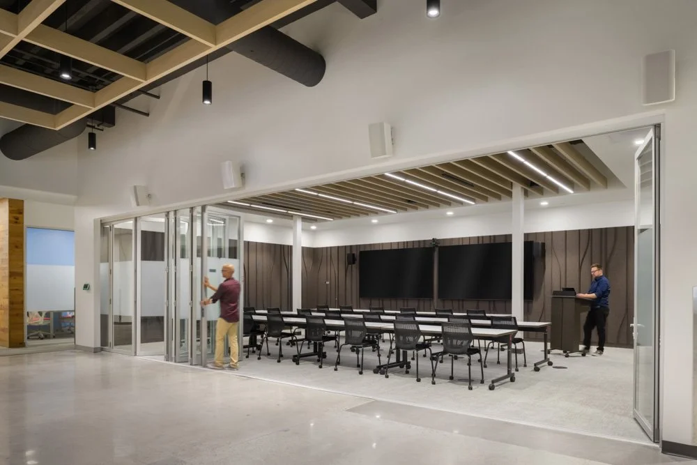 training room with operable glass partition and felt acoustical panels, with two men