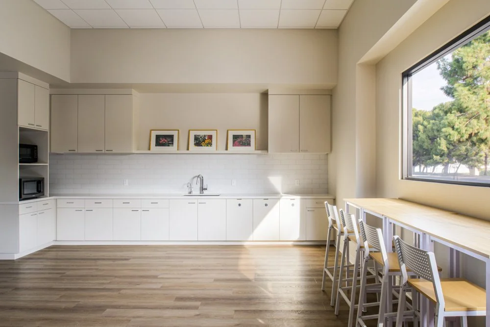 kitchen with white cabinets, white tiles, and bar seating