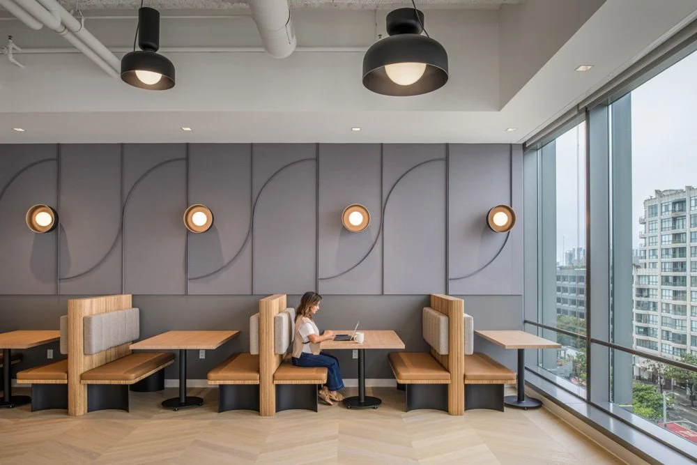 woman working in modern banquette seating with gray wall panels and window in san francisco commercial office