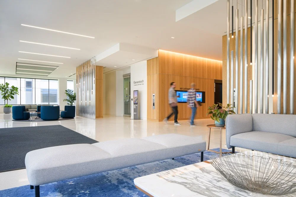 modern office lobby with metal tube screens and wood wall panels, two men walking
