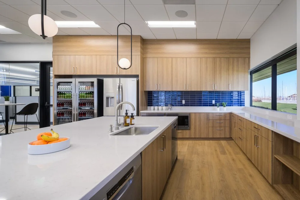 office kitchen with warm wood cabinetry, blue tile, large kitchen island with fruit bowl