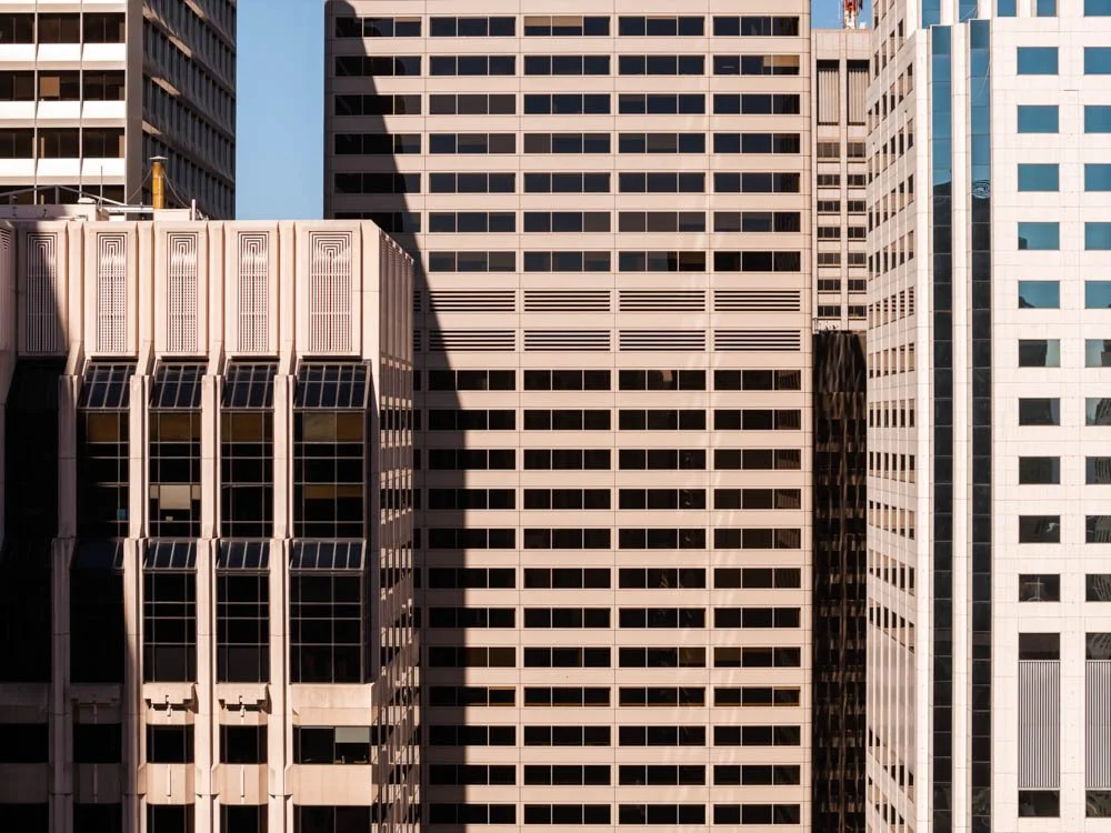 layers of highrise office building facades with a small piece of blue sky beyond