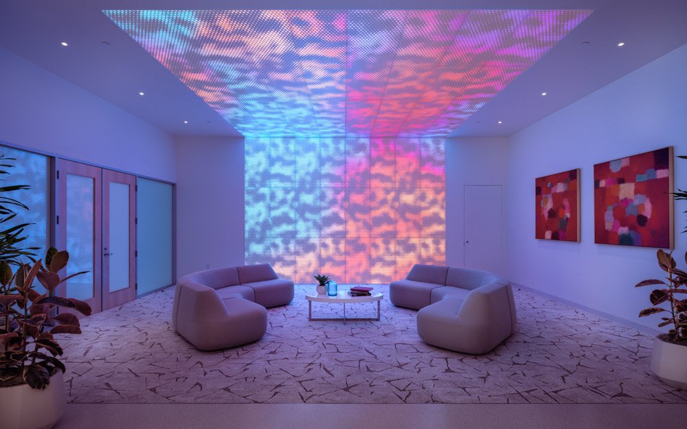 lounge with two curved sofas, backlit perforated wall and ceiling with colorful pattern