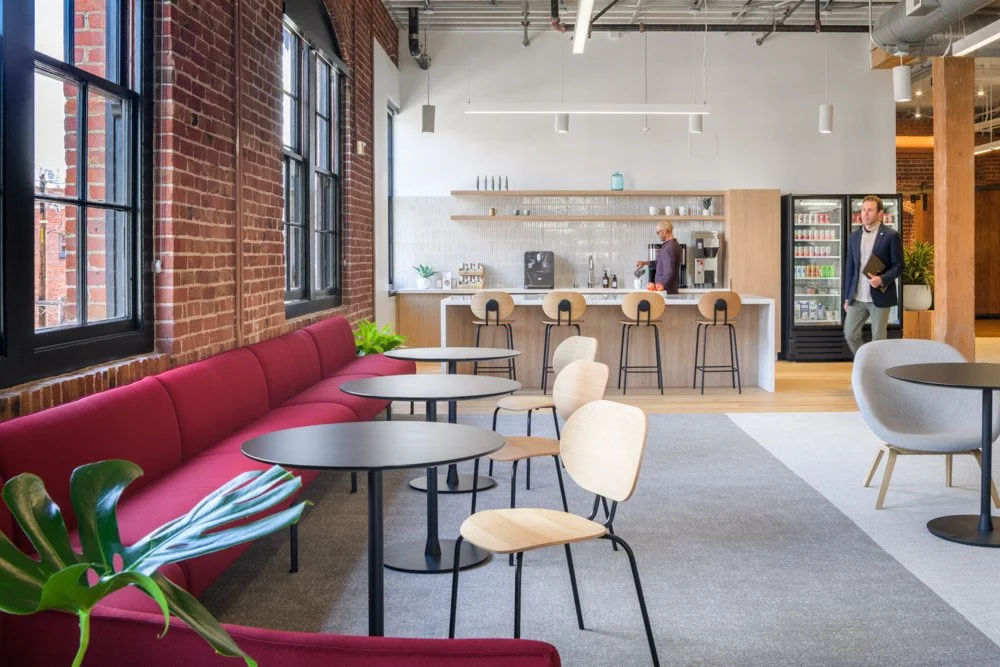 lounge with red banquette seating with modern kitchen in the background