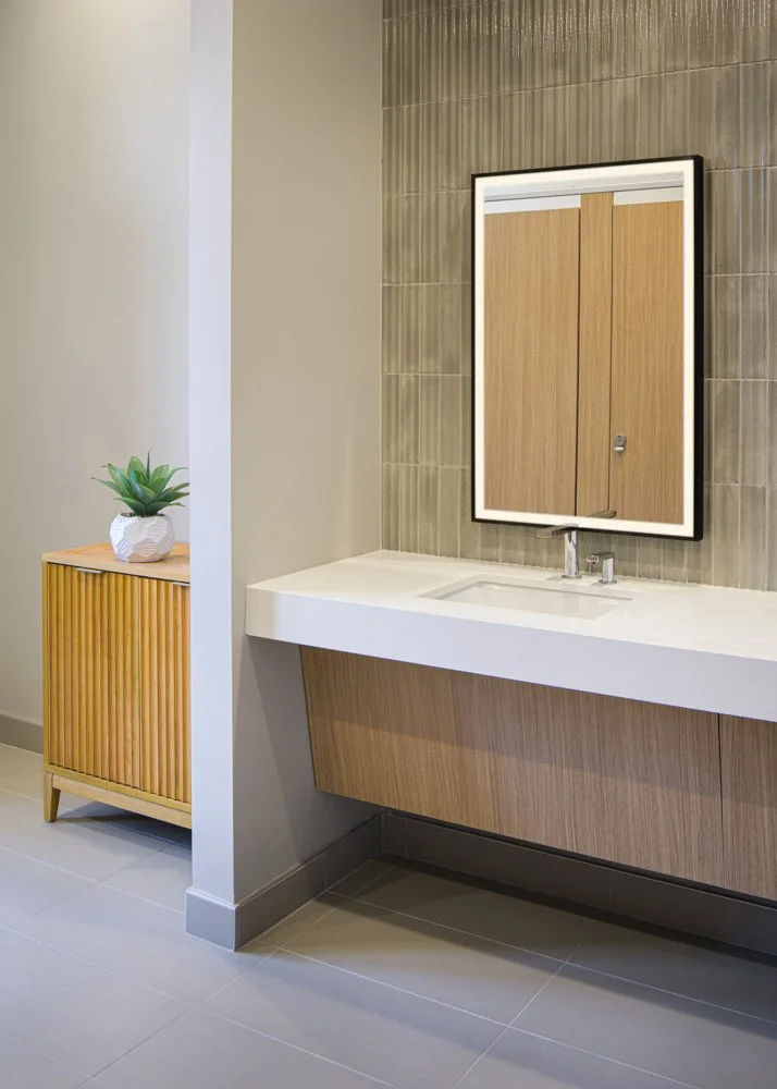 modern bathroom sink with sidelit mirror, beige tiles, gray floor tiles