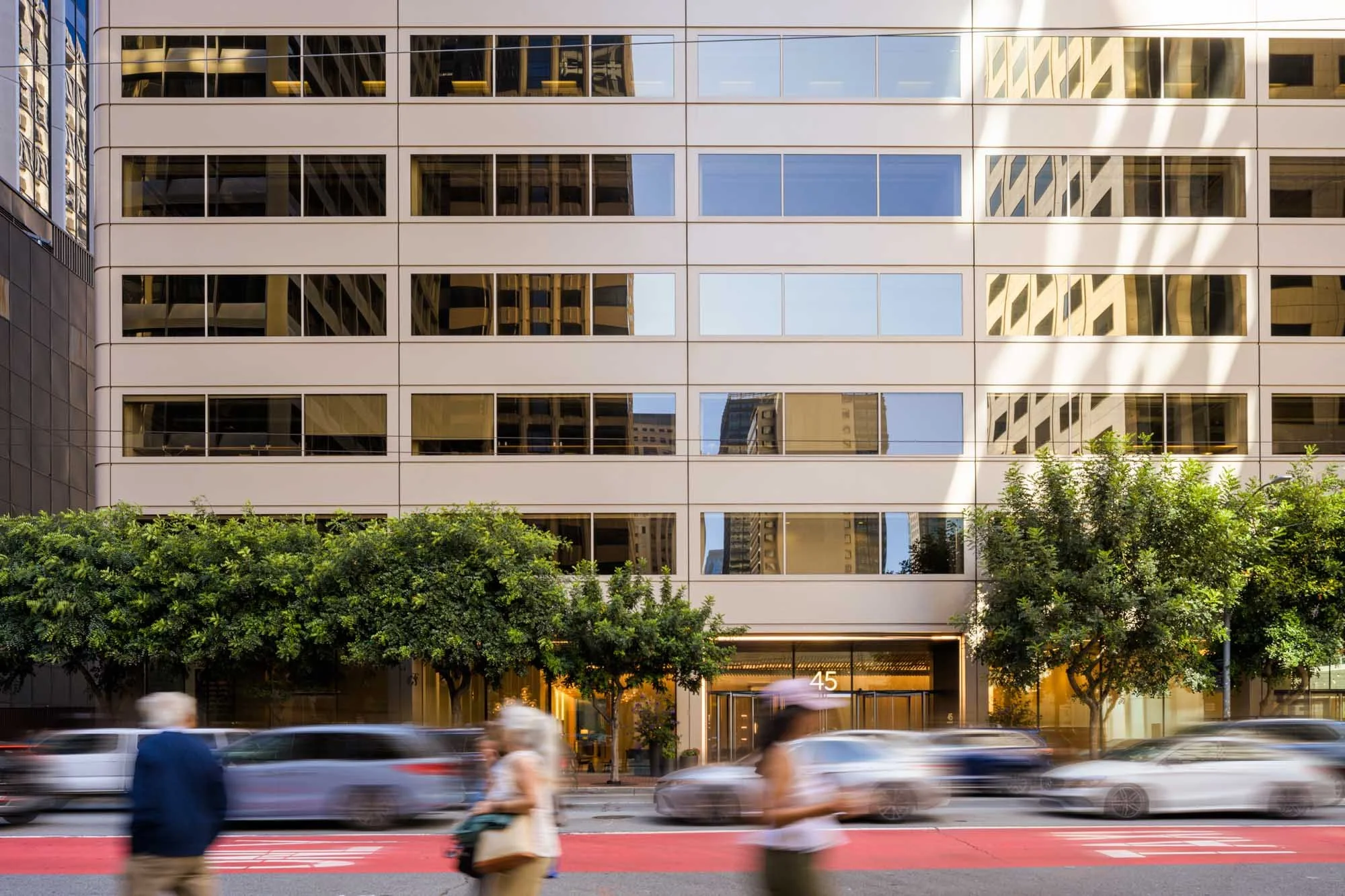 people and cars with motion blur in front of an office building