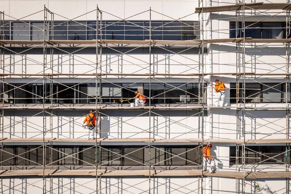 painters working on multiple levels of scaffolding, an example of construction photography