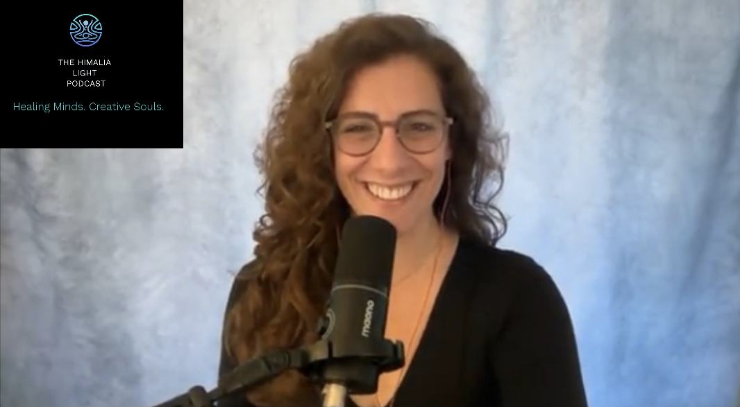 A smiling woman with curly brown hair and glasses sits in front of a microphone during a podcast recording. The background is a light, textured backdrop. The podcast logo in the top left corner reads 'The Himalaya Light Podcast' with the tagline 'Healing Minds. Creative Souls.'