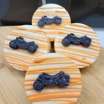 Cookies decorated with orange and white stripes and black motorcycle designs