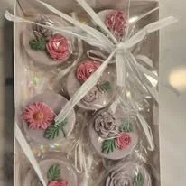 Packaged gift set of decorated cookies with flowers, wrapped in cellophane with a white ribbon.