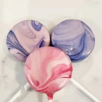 Three swirled lollipops with purple, blue, and pink colors