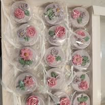 Display of pink and gray floral decorated cupcakes with roses and other flowers