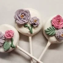 Lollipops decorated with purple and pink flowers and green leaves.