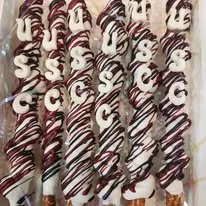 Multiple chocolate-dipped pretzels with white and dark chocolate drizzle, arranged vertically.