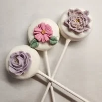 Four lollipop candies with floral and cartoonish designs