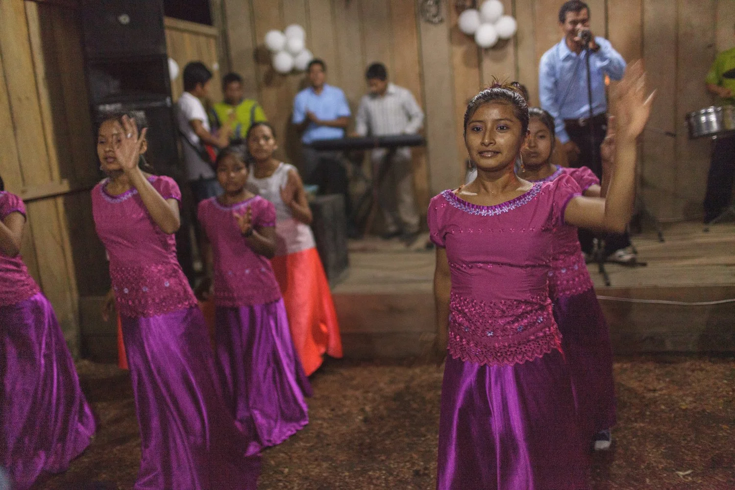 Young girls in bright dresses perform a worship dance during a church service in an Amazon village.