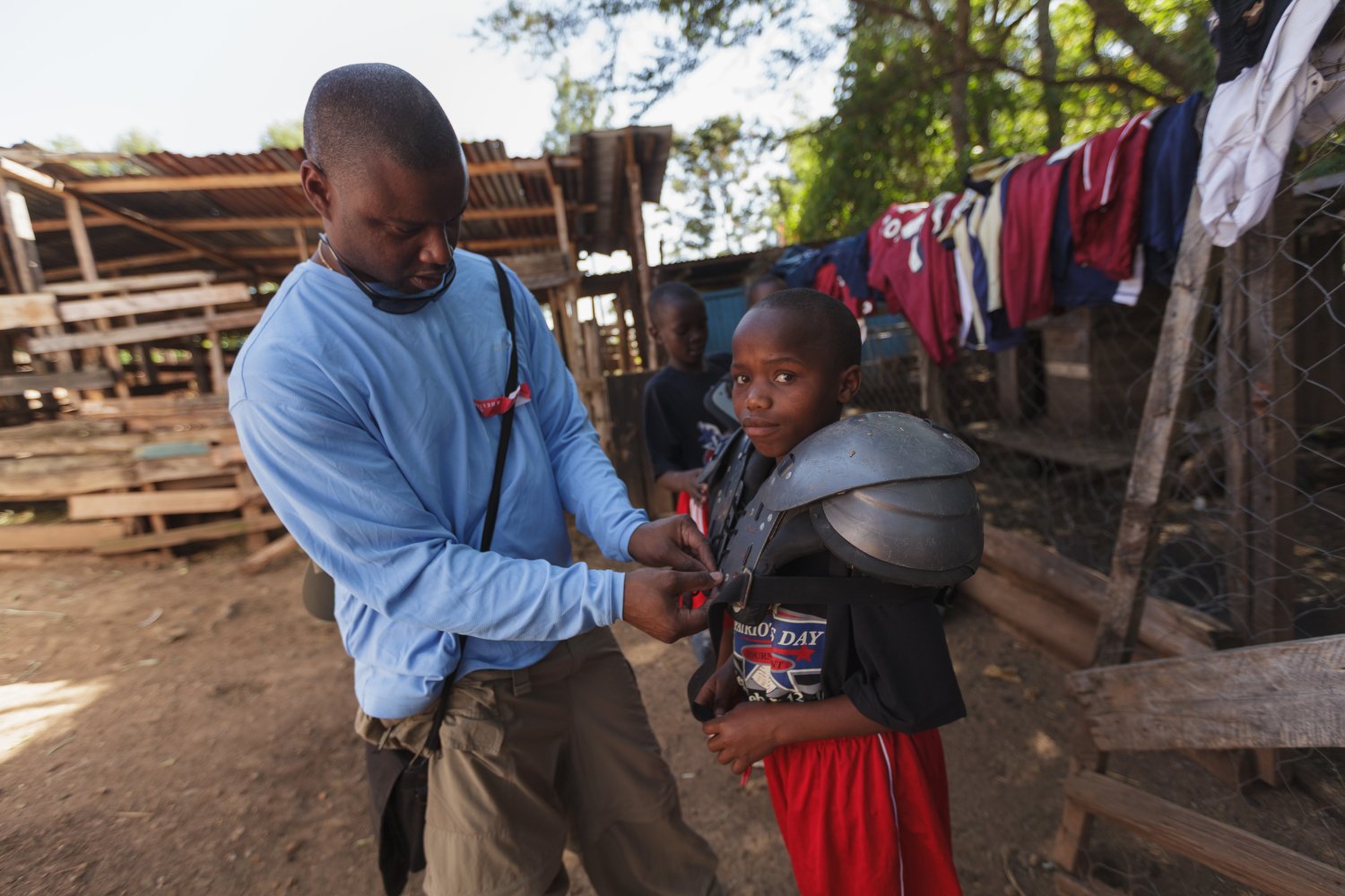 Former NFL cornerback Dexter Davis helps a Kenyan youth adjust football shoulder pads during an FCA mission trip in Nakuru, Kenya, January 2012.