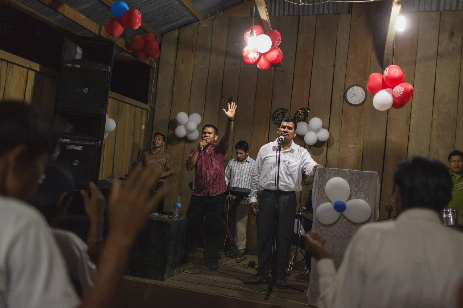 Worship leaders guide the congregation with music and song during a village church service.