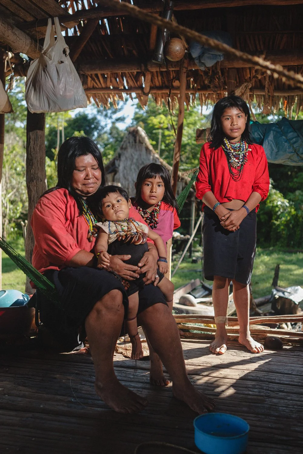 An Amazonian mother and her children pose together outside their home.