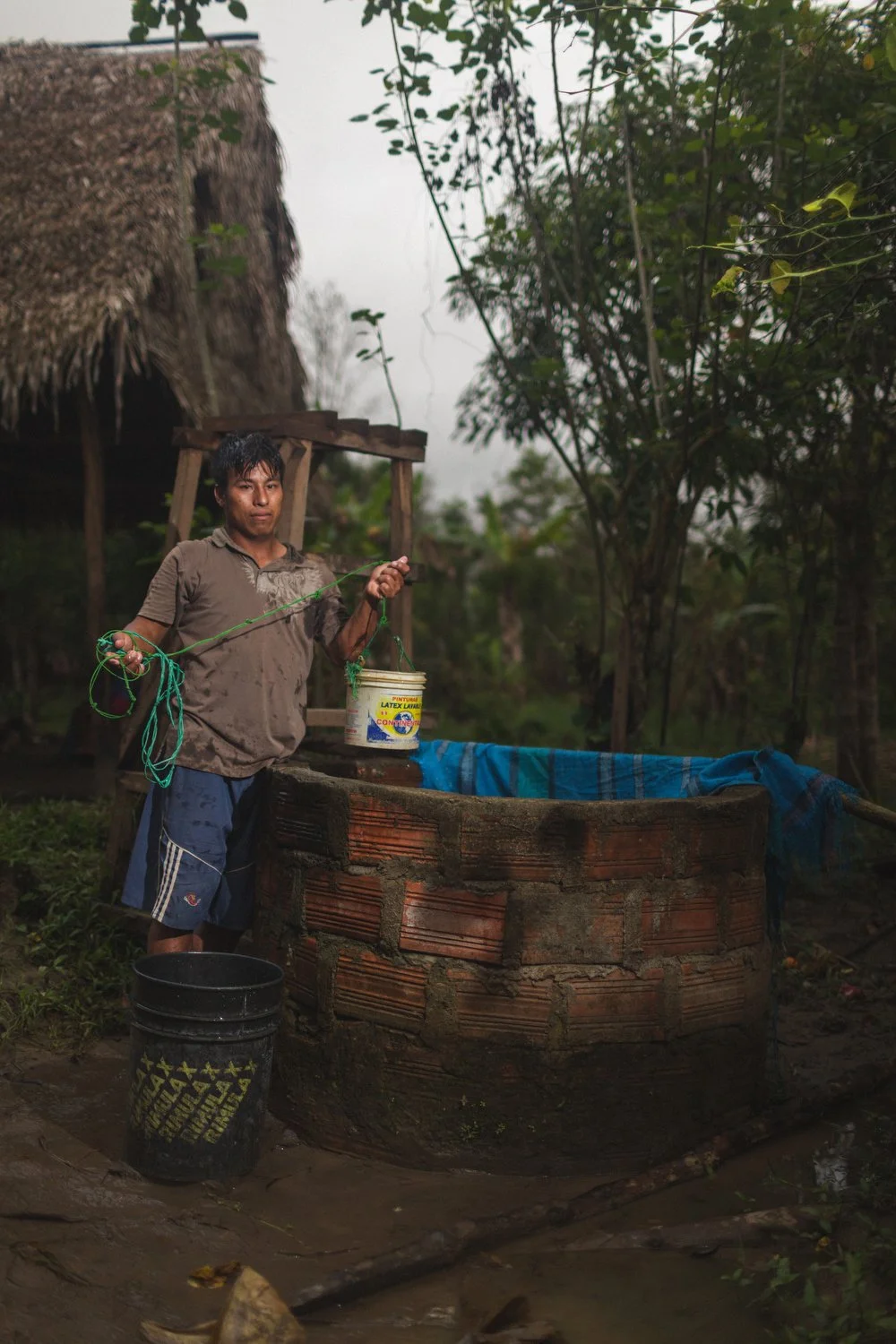 A villager pulls up fresh water from a handmade well in the Amazon rainforest of Peru.
