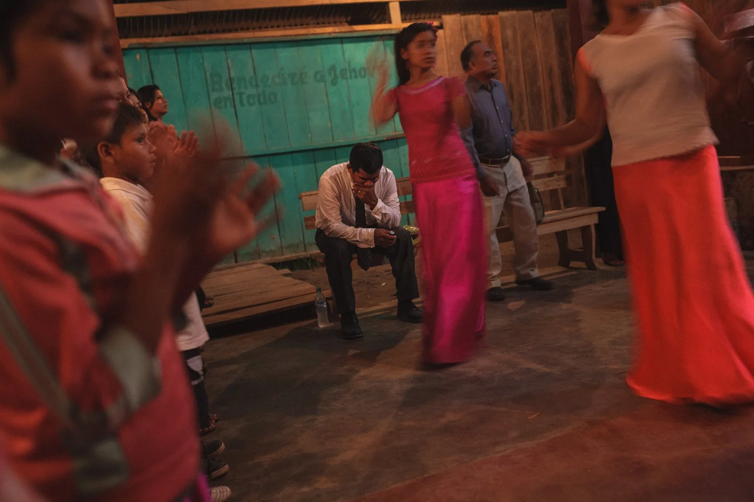 Pastor Jorge sits in deep reflection during a lively worship service in the Amazon.