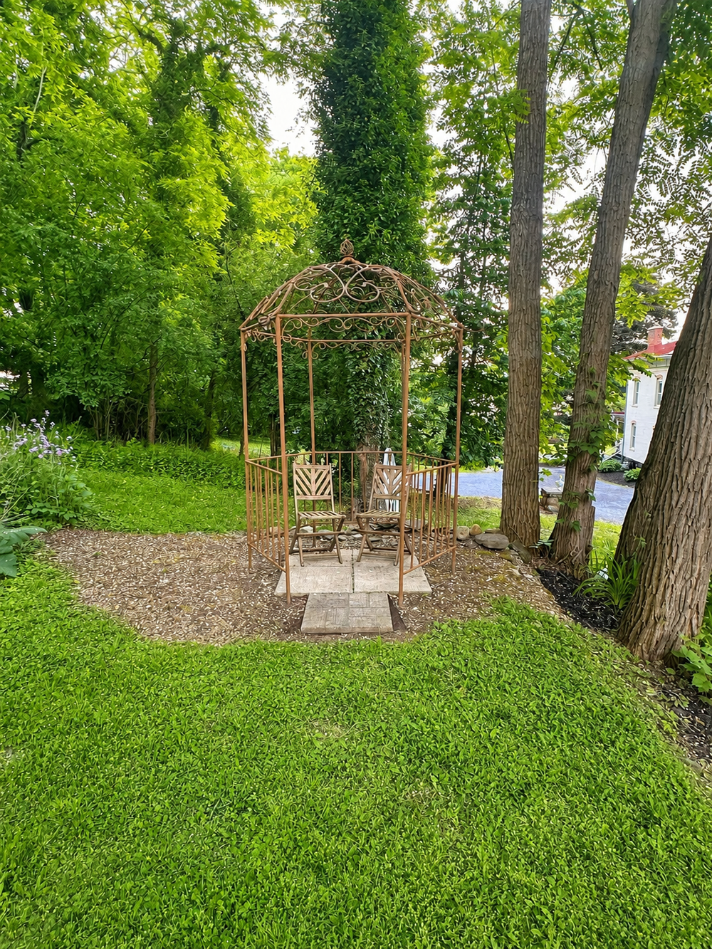 Backyard garden arbor with seating area at Keuka Cove House