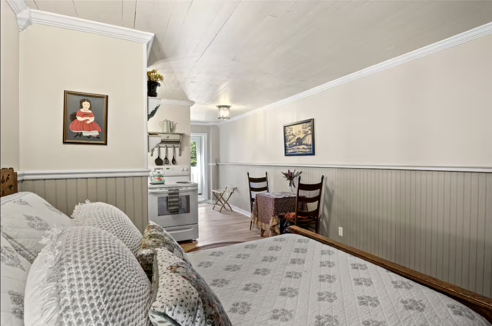 Unit 2 Studio Suite view showing the bed, dining table, kitchenette, and private entry area