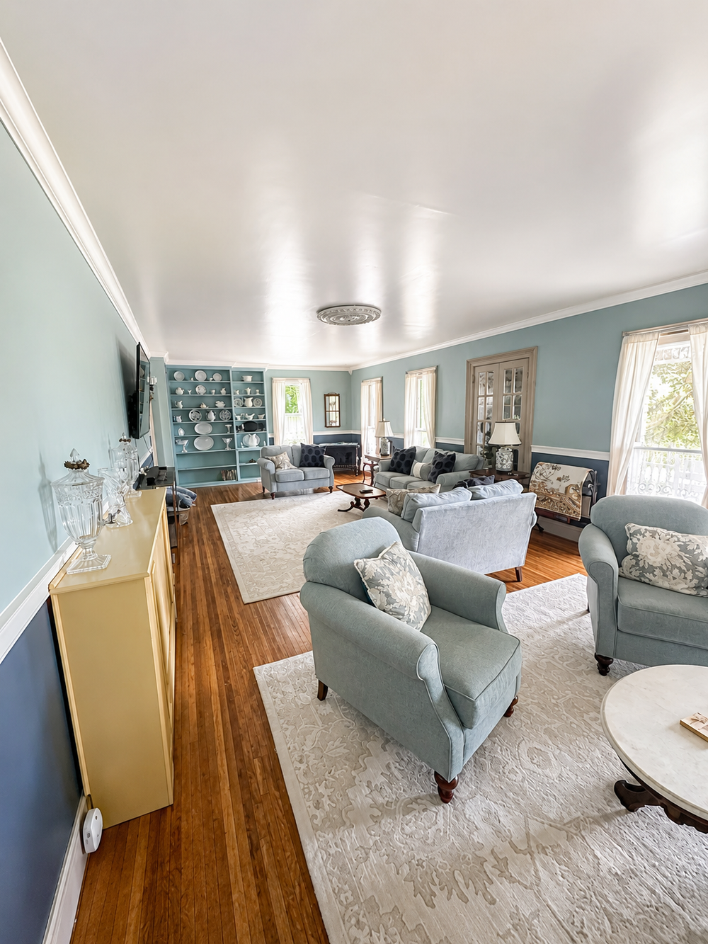 Wide view of the Unit 1 living room gathering space with multiple seating areas