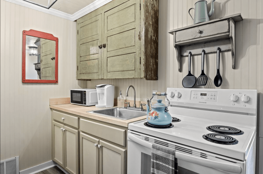 Unit 2 Studio Suite kitchenette with sink, stove, microwave, coffee setup, and refrigerator