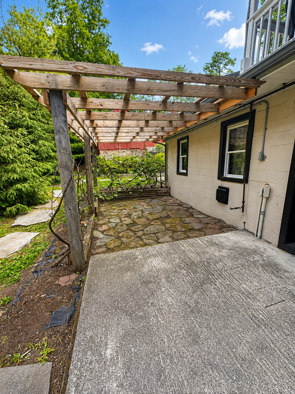 Backyard stone patio and pergola area beside the house