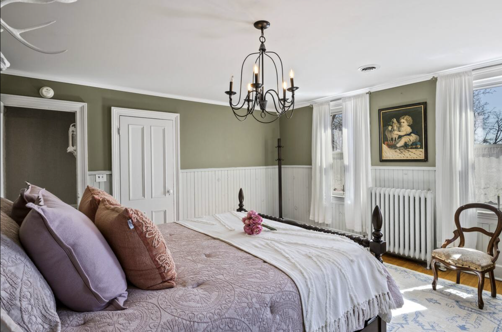 Unit 1 Bedroom 2 side view with queen bed, nightstands, and natural light