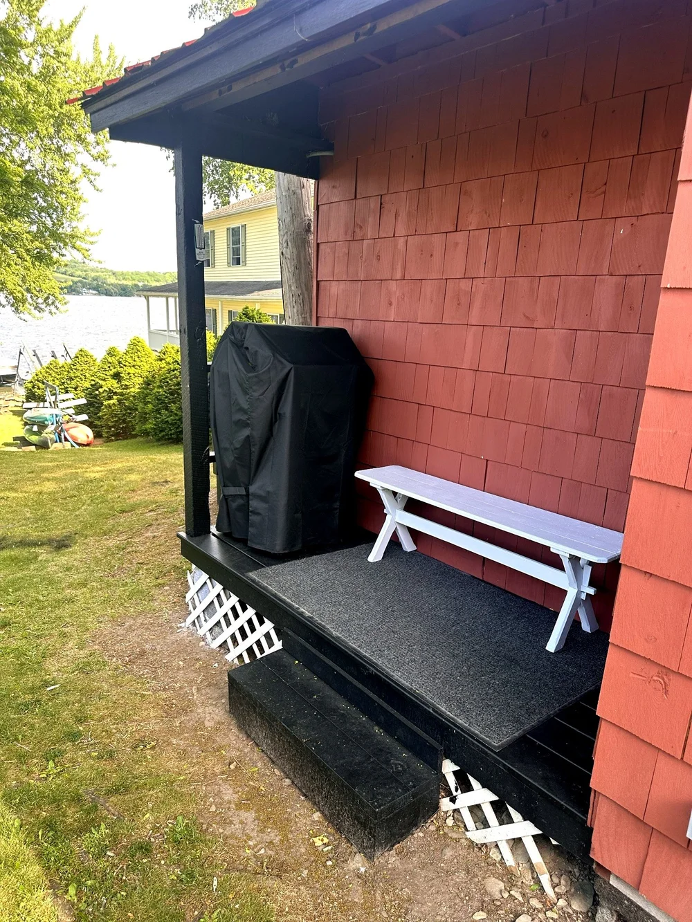 Side deck of the boathouse lounge with grill and bench seating