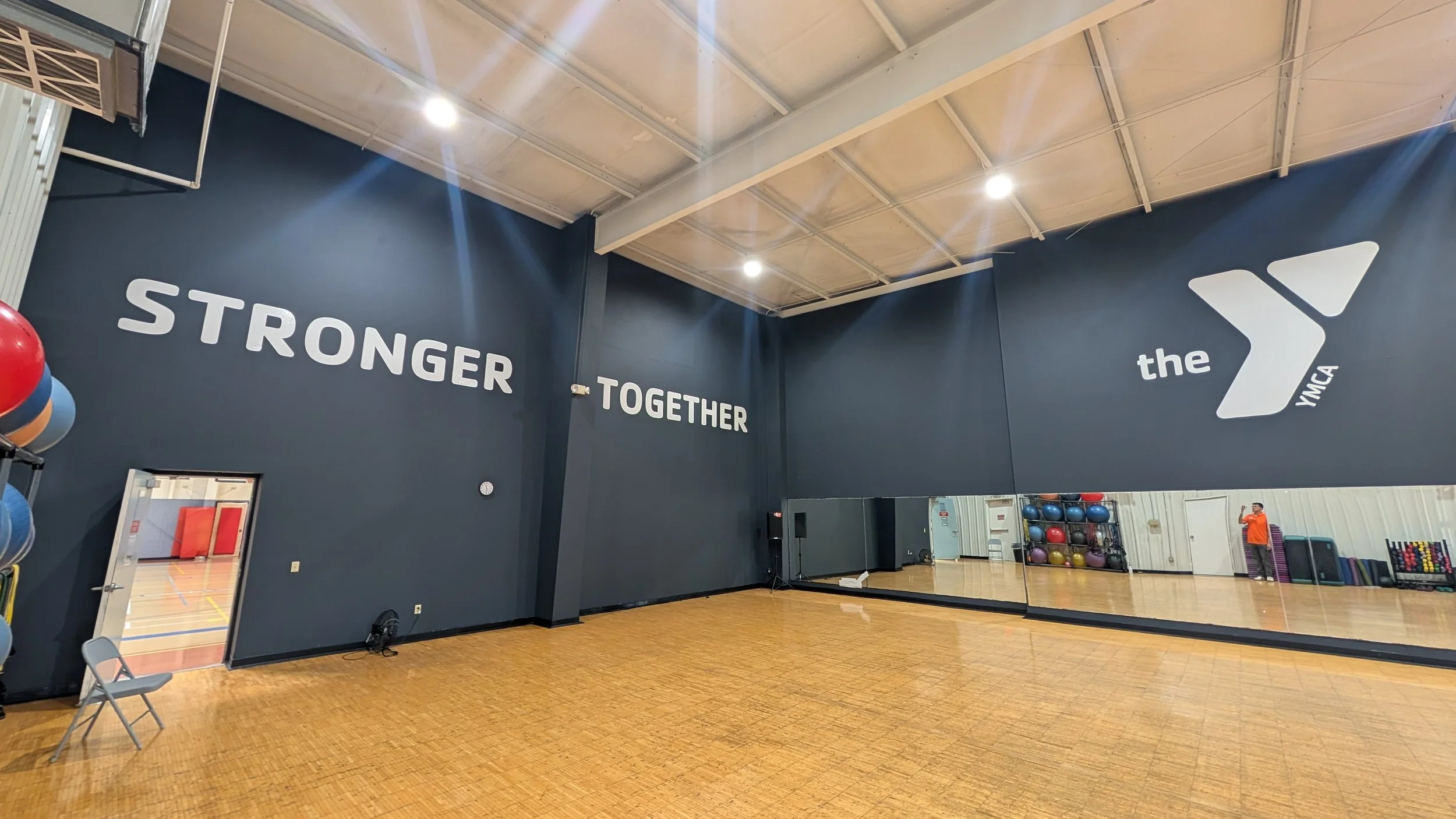 A white YMCA and the words STRONGER - TOGETHER logo graphic on two walls