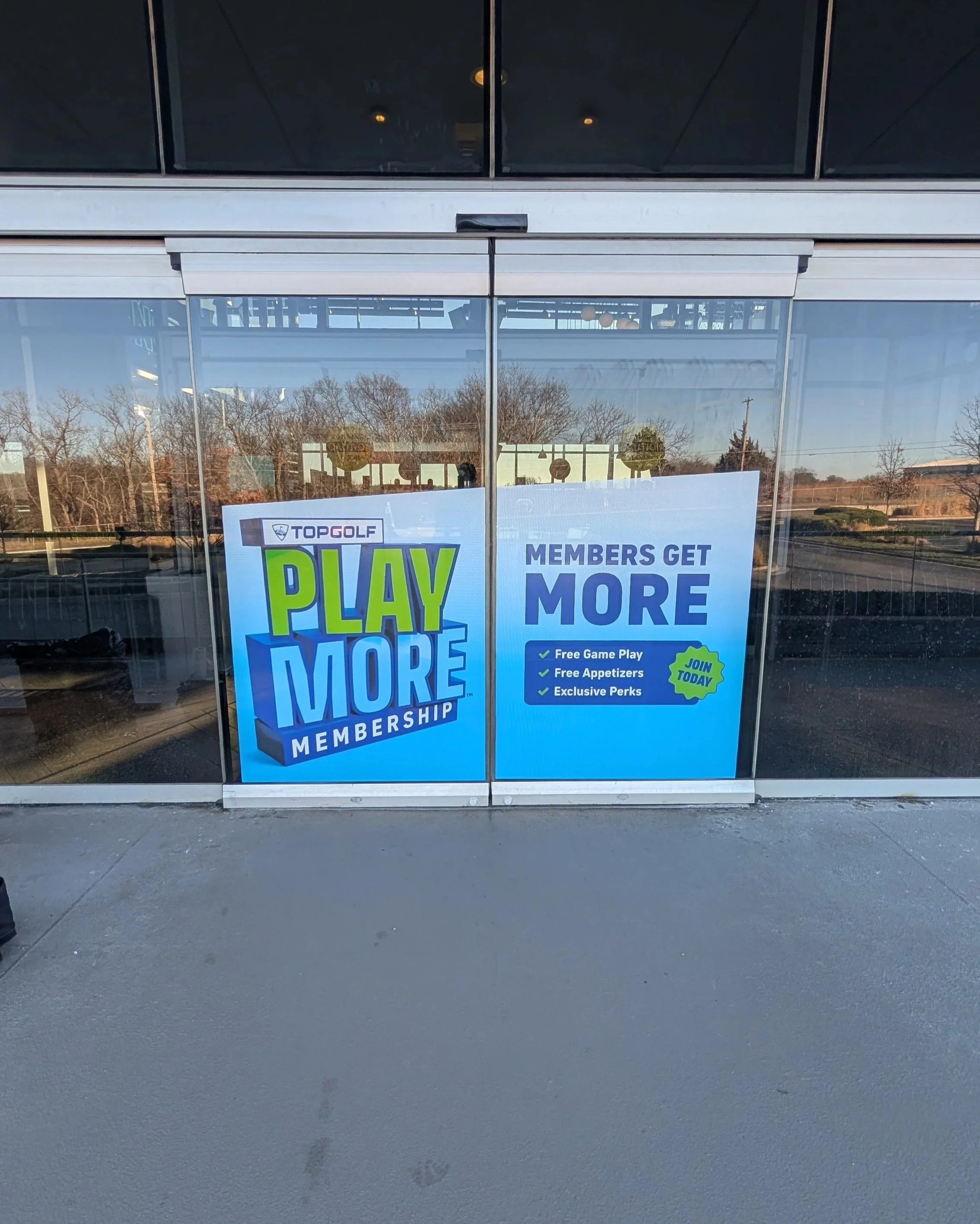 Play More membership graphic on a glass door