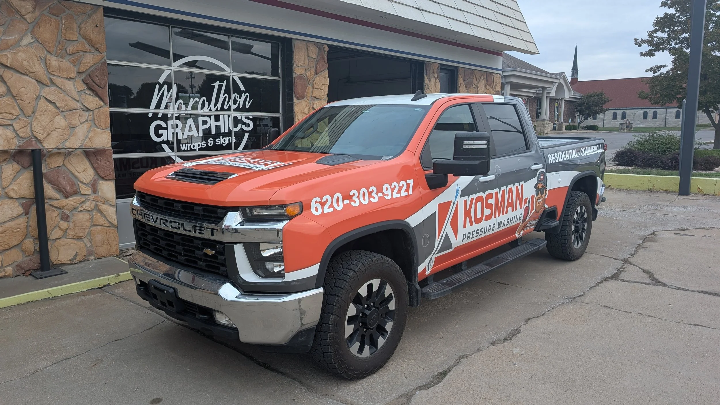 Truck wrapped with the Kosman logo from the side